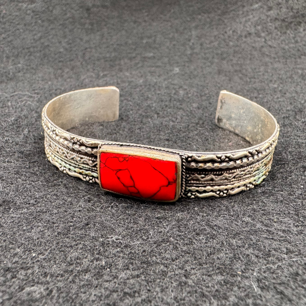 Bracelet artisanal Nuristan Afghanistan, pierre ovale rouge-orangé sur bande striée argent allemand