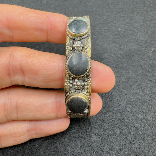Bracelet ajustable Nuristan Afghanistan porté au poignet, pierres noires