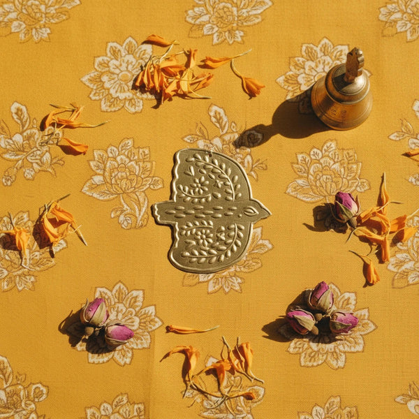 KIFF KIFF Amal hammered gold metal dove ex-voto ornament on a yellow floral fabric background with dried flowers