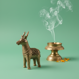 KIFF KIFF brass deer statuette standing next to a traditional lit incense burner with rising smoke on green background