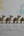 Four KIFF KIFF brass dromedary statuettes with intricate textured detailing arranged in a row on a concrete surface.