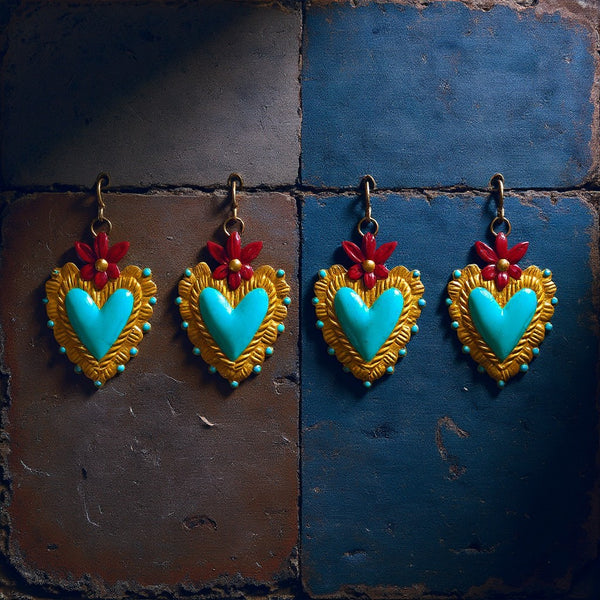 Quatre ex-voto KIFF KIFF modèle Betty en forme de cœur turquoise, doré et bordeaux, suspendus sur un mur en briques.
