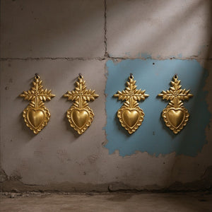 Quatre ex-voto Ernest KIFF KIFF en métal doré, cœurs sacrés artisanaux fixés sur un mur gris et bleu