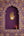 Ex-Voto Naïa KIFF KIFF en métal doré en forme de main stylisée avec un cœur, fixé dans une niche murale violette.