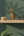 KIFF KIFF gold metal deer statuette on a wooden shelf with a small woven basket and dried flowers