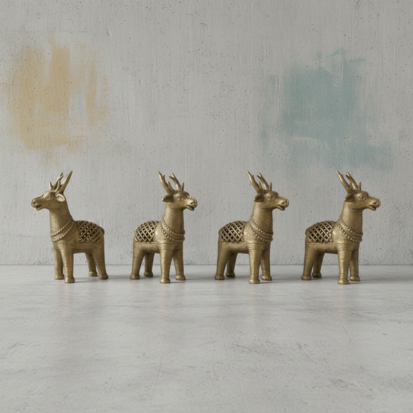 Four KIFF KIFF gold-toned deer statuettes with intricate textured patterns standing in a row on a concrete surface.