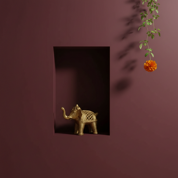 KIFF KIFF gold metal elephant figurine with intricate engraved textures displayed in a dark red wall niche