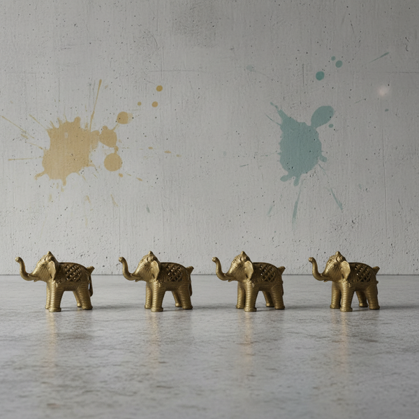 Four KIFF KIFF gold metal elephant figurines with intricate textured engravings displayed on a concrete surface.