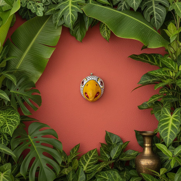 Masque mural KIFF KIFF Jatayu en papier mâché blanc avec bec jaune, entouré de feuilles tropicales sur fond rouge.
