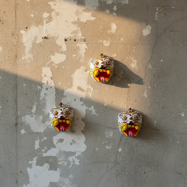 Trois petits masques muraux KIFF KIFF en papier mâché représentant des tigres blancs artisanaux d'Inde sur un mur