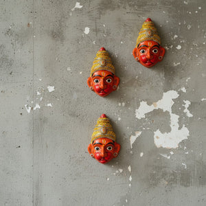 Trois masques muraux KIFF KIFF représentant Hanuman en papier mâché orange peint à la main sur un mur en béton