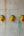 Trois masques muraux KIFF KIFF artisanaux indiens, visage jaune et coiffe verte, fixés sur un mur en béton.
