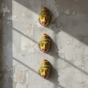 Trois masques muraux artisanaux KIFF KIFF de Narasimha Swami en papier mâché peint à la main sur un mur texturé.