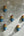KIFF KIFF petits masques muraux artisanaux de Radha en papier mâché bleu, peints à la main, disposés sur un mur gris.