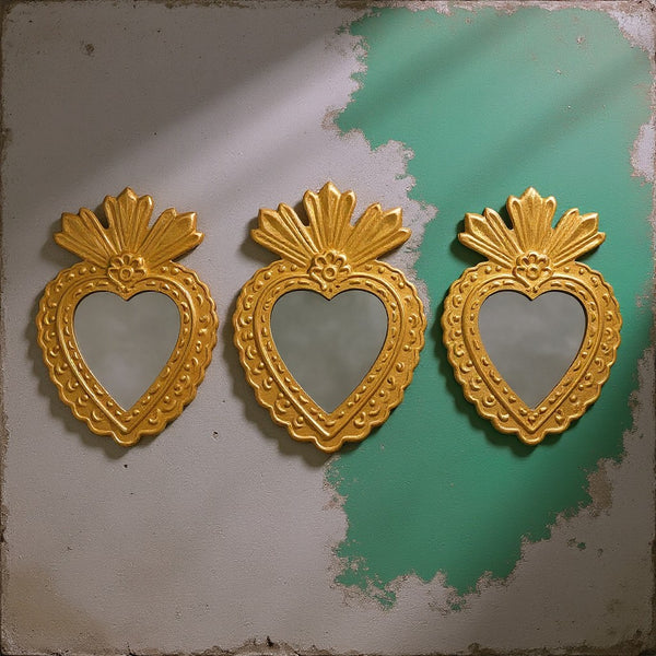 Trois miroirs coeur ex-voto dorés Fifi de KIFF KIFF avec bordures festonnées artisanales sur fond texturé