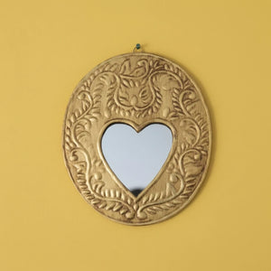 Miroir mural KIFF KIFF Gemma ovale en métal doré martelé avec un centre en forme de cœur sur fond jaune