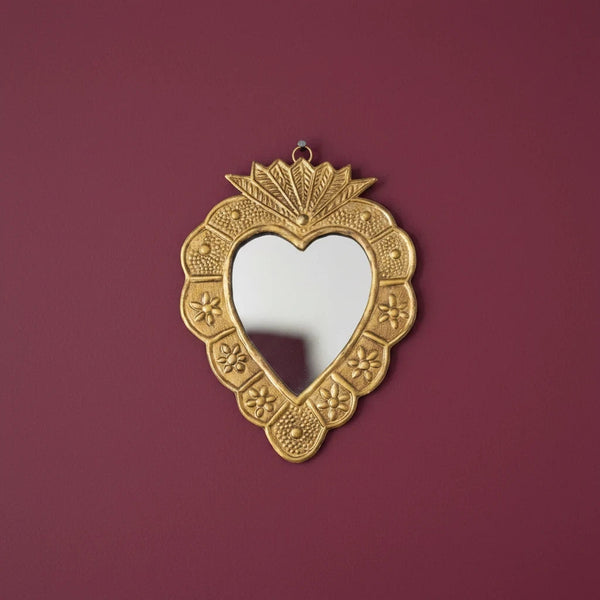 Miroir ex-voto en forme de cœur KIFF KIFF en métal doré martelé avec détails floraux, fixé sur un mur bordeaux.