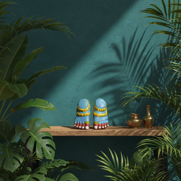 Duo de pieds de Lakshmi KIFF KIFF en papier mâché bleu peint à la main, posés sur une étagère dans un décor exotique.