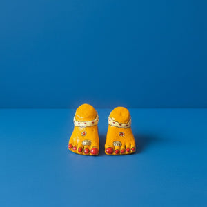 Duo de pieds de Lakshmi KIFF KIFF en papier mâché jaune peint à la main, symboles artisanaux de prospérité indiens.