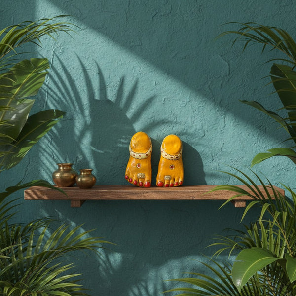 Pieds de Lakshmi KIFF KIFF jaunes en papier mâché artisanal posés sur une étagère en bois avec des pots en laiton