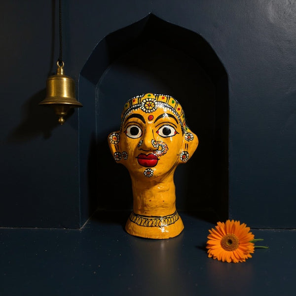 Statuette KIFF KIFF de tête de femme hindoue en papier mâché jaune peinte à la main, posée dans une niche décorative.