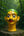 Statuette KIFF KIFF de visage d'homme hindou en papier mâché peint à la main, posée sur un socle en pierre en forêt.