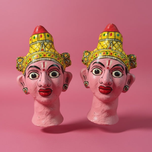 Deux statuettes KIFF KIFF en papier mâché représentant des visages hindous peints à la main dans des tons rose et or.