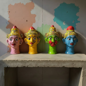 Quatre statuettes KIFF KIFF en papier mâché représentant des visages hindous colorés peints à la main sur une étagère