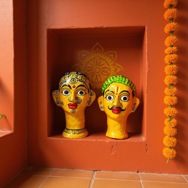 Deux statuettes KIFF KIFF en papier mâché représentant des visages indiens peints à la main dans une niche orange.