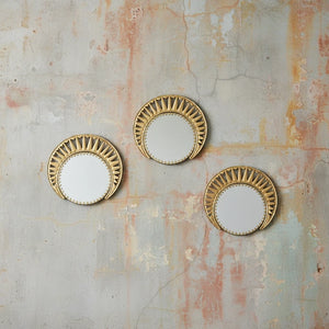 Three KIFF KIFF Zoya circular mirrors with decorative gold metal frames mounted on a textured rustic wall.