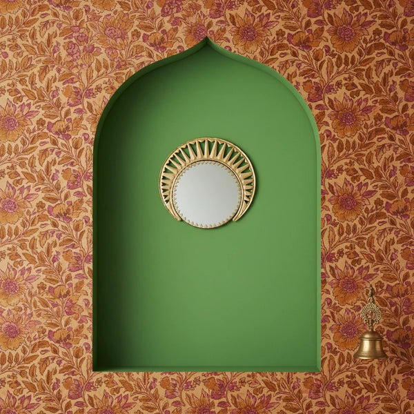 KIFF KIFF Zoya circular wall mirror with a decorative gold metal frame, 26 cm diameter, displayed in a green niche.